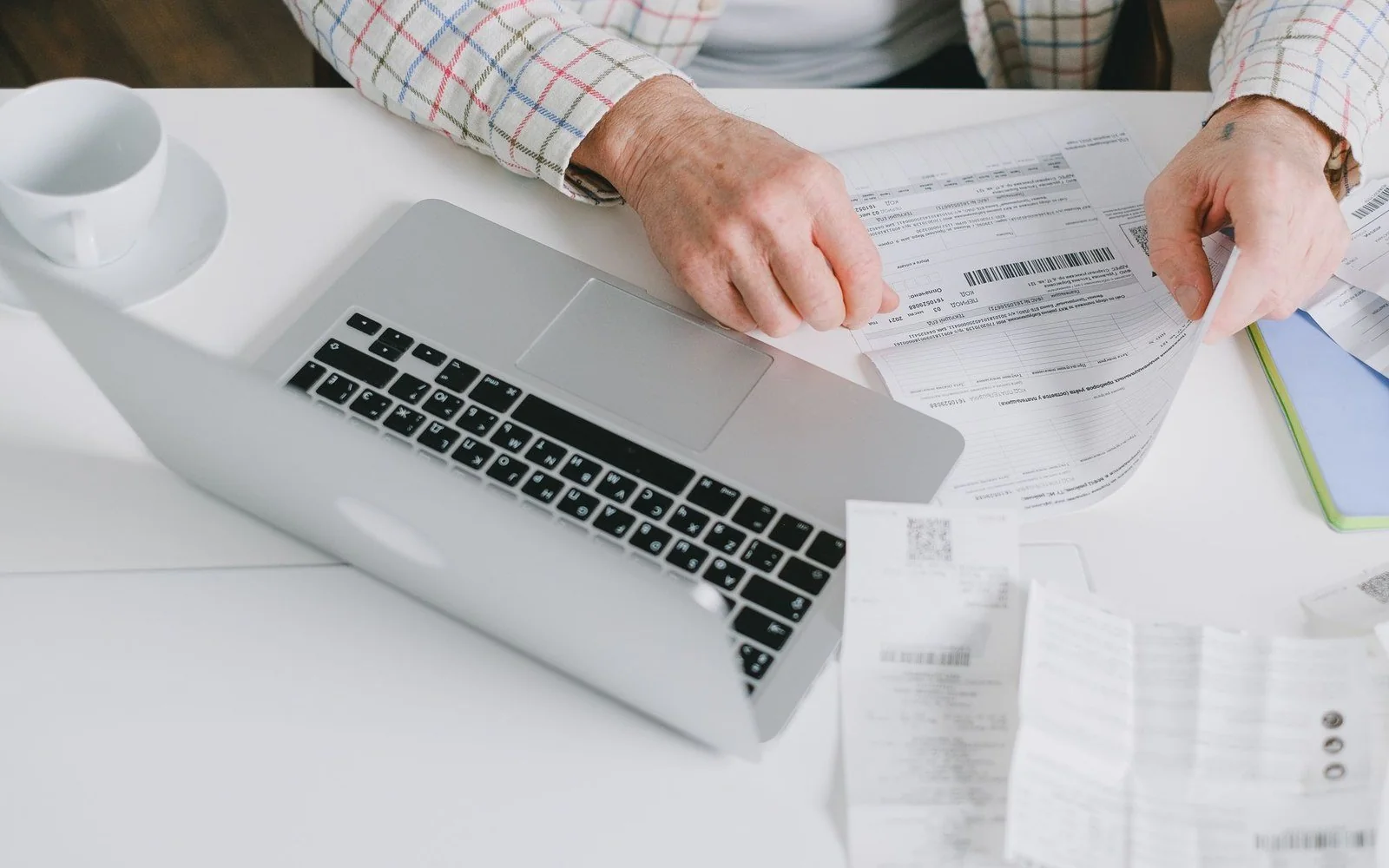 Reviewing business paperwork alongside a laptop