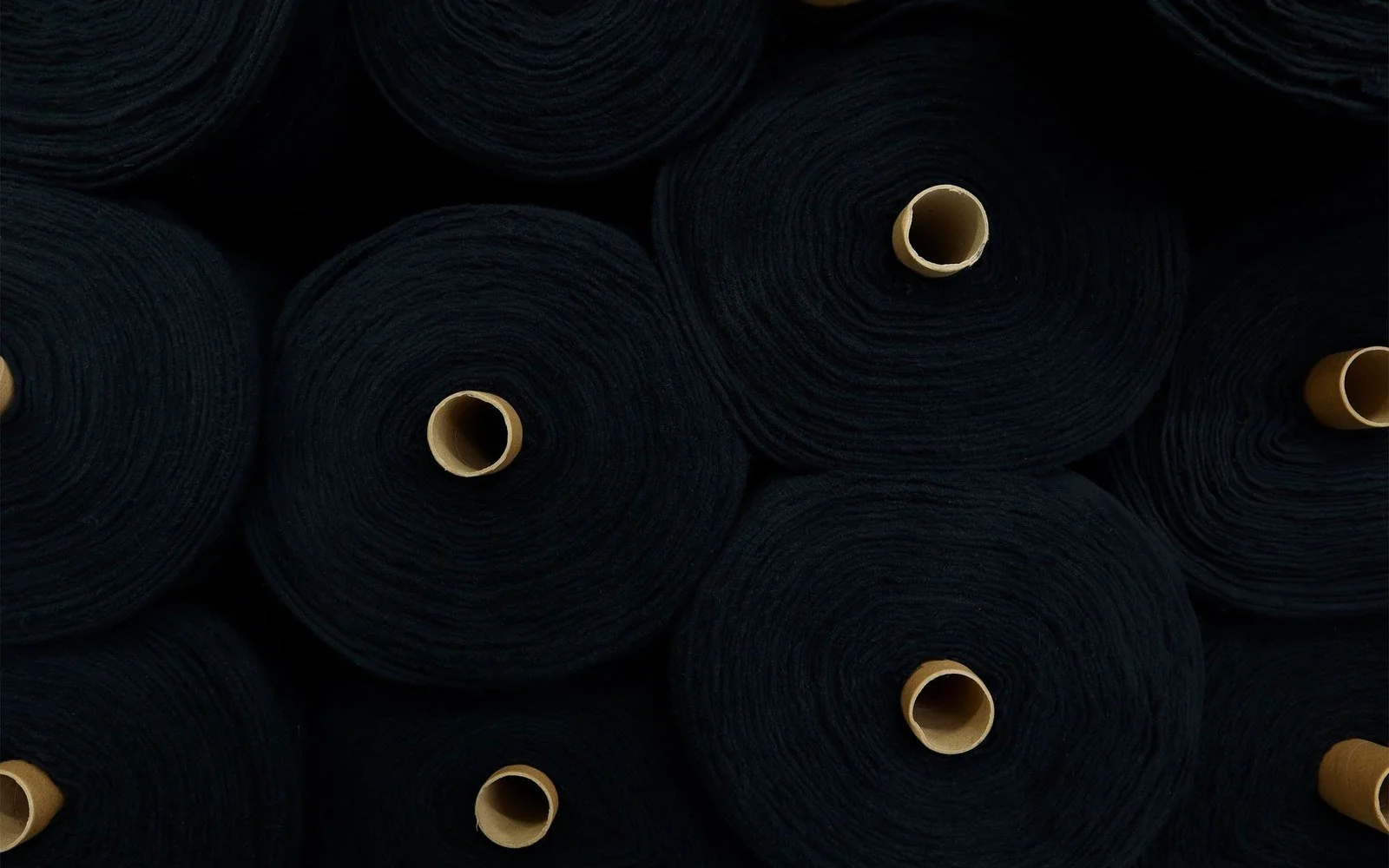 Bulk rolls of black fabric prepared for textile supply